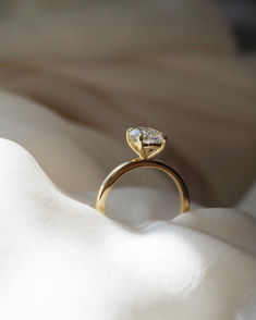 a diamond ring sitting on top of a white cloth