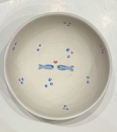 a white bowl with blue fish painted on it