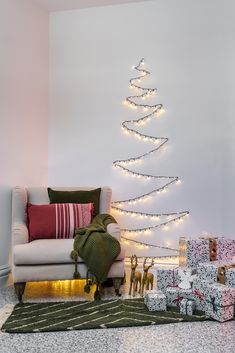 a living room with presents and a christmas tree on the wall next to the couch