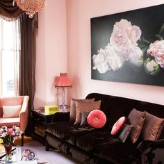 a living room filled with furniture and a painting on the wall