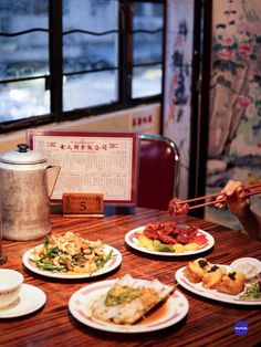 a table topped with plates of food next to a tea pot