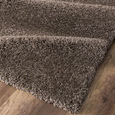 a brown rug on top of a wooden floor next to a wood flooring board