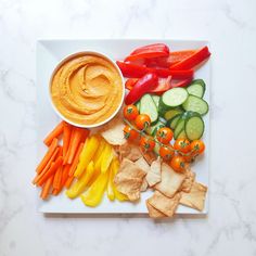 a white plate topped with veggies and dip