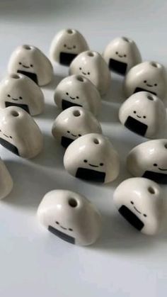 several white ceramic beads with black dots and faces on them, arranged in a circle