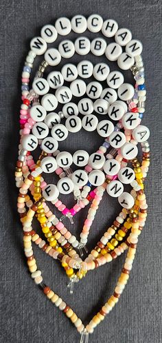 several bracelets with beads and letters on them