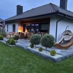 an outdoor patio with chairs and plants on the lawn