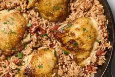 chicken and rice in a skillet with garnishes on the side, ready to be eaten