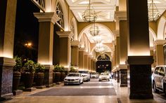 cars are parked in the middle of an indoor walkway at night time with lights on