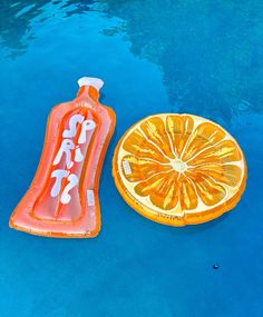 an inflatable orange slice and tube float next to a swimming pool with blue water