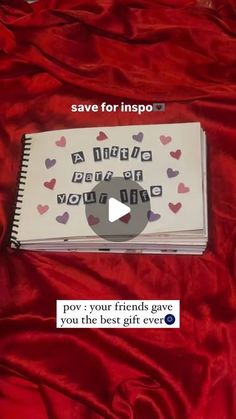 a book with hearts on it sitting on a red sheet