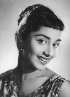 an old black and white photo of a woman smiling for the camera with her eyes wide open