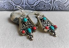 Here is a very beautiful pair of earrings made of Tibetan silver, turquoise and coral. This pair of earrings is inspired by traditional Tibetan jewelry, a unique model! They will accompany your outfits in a vintage ethnic style. Very nice quality. They are mounted on 925 silver. Length under attachment: 4.5 cm They are shipped with a small traditional fabric pouch and tips. The shipment will be fast and neat. Namaste! Ethnic Tibetan Turquoises Earrings, Tibetan Jewelry, Fabric Pouch, Turquoise And Coral, Traditional Fabric, Ethnic Earrings, Coral Turquoise, Ethnic Style, Silver Turquoise