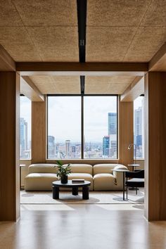 a living room filled with furniture next to a large window overlooking the cityscape