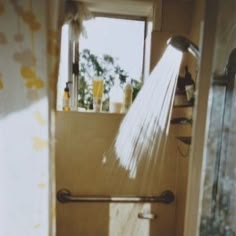 a shower head with water flowing from it's side in front of a window