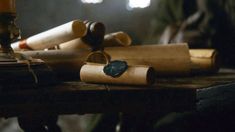 several rolled up papers sitting on top of a wooden table next to a sewing machine