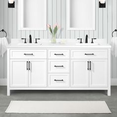 a white bathroom with two sinks and mirrors