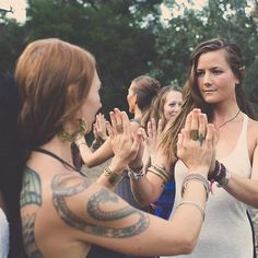 a group of women standing next to each other with their hands in front of them