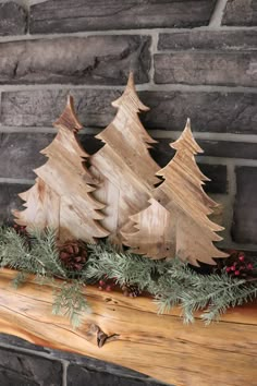 three wooden christmas trees sitting on top of a mantle