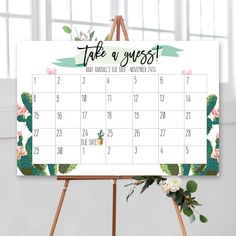 a desk calendar with cactus and flowers on it, sitting next to a easel