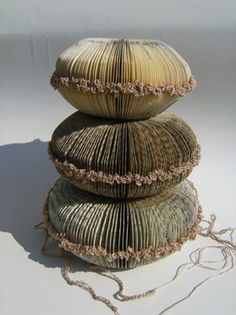 three stacked stacks of yarn sitting next to each other on top of a white surface