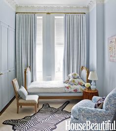 a bedroom with blue walls and curtains, a zebra rug on the floor and a bed in the corner