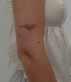 a woman's arm with a small tattoo of a cheetah on it