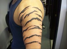 a woman's arm is covered with black ink and has an animal pattern on it