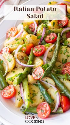 a white plate topped with potatoes, green beans and tomatoes