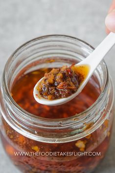 a spoon full of food sitting in a jar