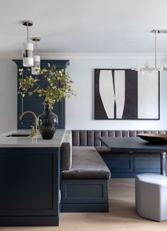 a vase with some flowers in it sitting on a kitchen counter next to a bench