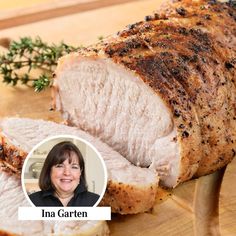 a woman smiling next to a sliced pork on a cutting board with herbs and spices