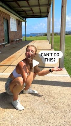 a woman squatting down in front of a building with a sign that says can't do this?