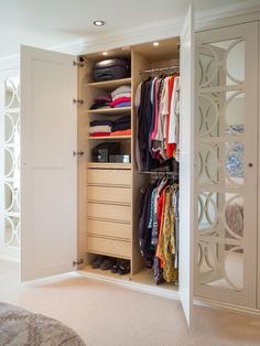 an open closet with clothes and shoes in it