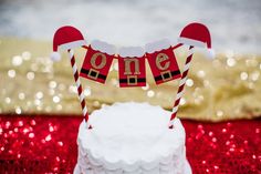 a white cake topped with a santa hat and one sign