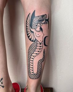 a woman's leg with an egyptian tattoo on it