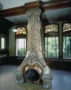 an ornate fireplace in the middle of a room with stained glass windows and wood trimmings