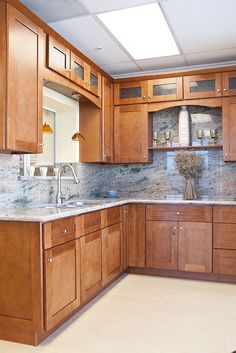 a kitchen with wooden cabinets and marble counter tops