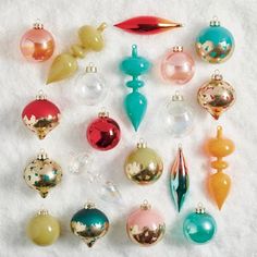 an assortment of christmas ornaments on a white surface