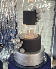 a three tiered cake with silver decorations on top