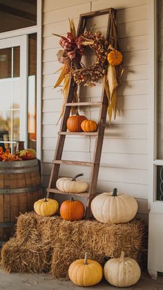 pumpkins and hay bales are stacked on the porch