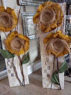 three yellow flowers sitting on top of a wooden block with twine and burlocks