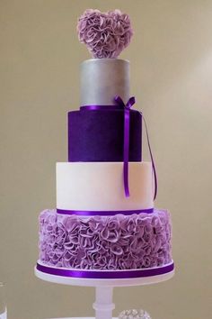 a three tiered cake with purple flowers on top