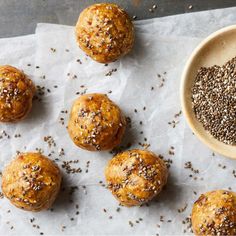 several balls of bread with sesame seeds on top and a bowl of chives next to it