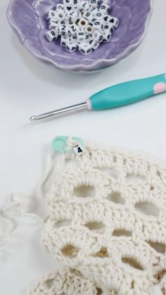 crocheted doily next to a plate with a crochet hook on it