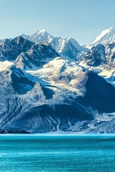 the mountains are covered in snow and blue water