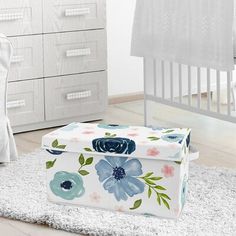 a baby's room with white furniture and blue flowers