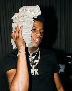 a young man holding up a stack of money