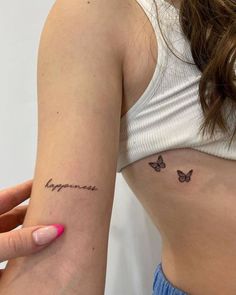 a woman's left arm with a small tattoo on it that says happiness and butterflies