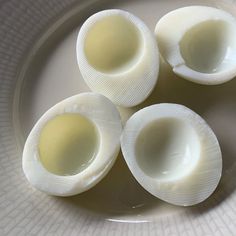 four hard boiled eggs on a white plate