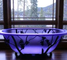 a bathtub sitting in front of a window next to a wooden floor and wall